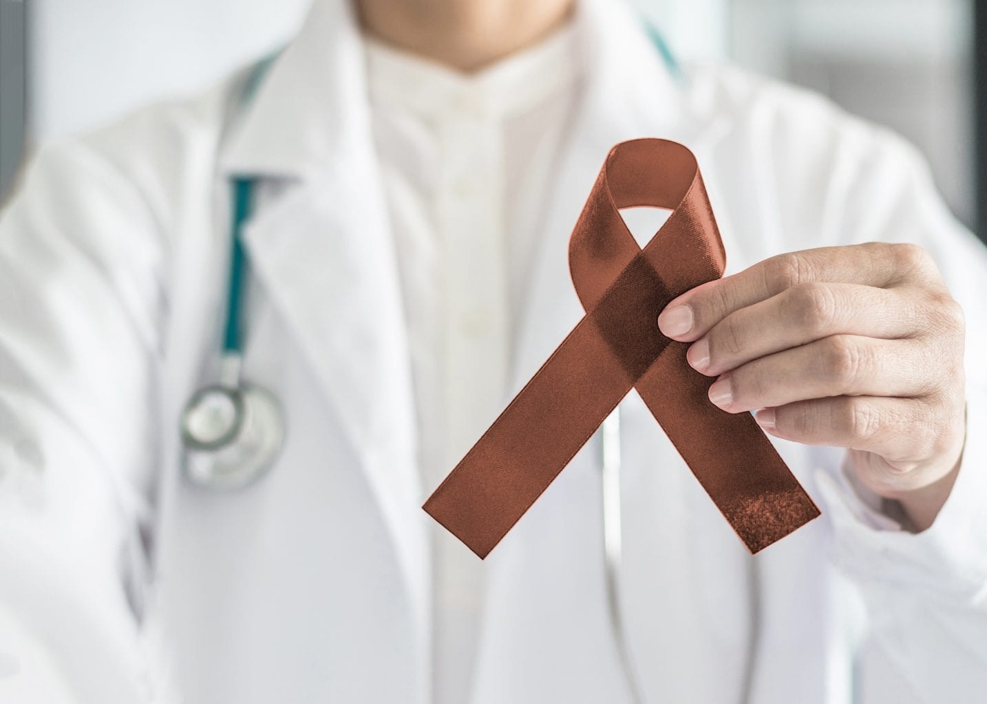 Copper Brown Awareness Ribbon On Doctor’s Hand, Symbolic Color For Anti Tobacco, Colon Colorectal Cancers, Herpes Simplex Virus (hsv 1 And Hsv 2)